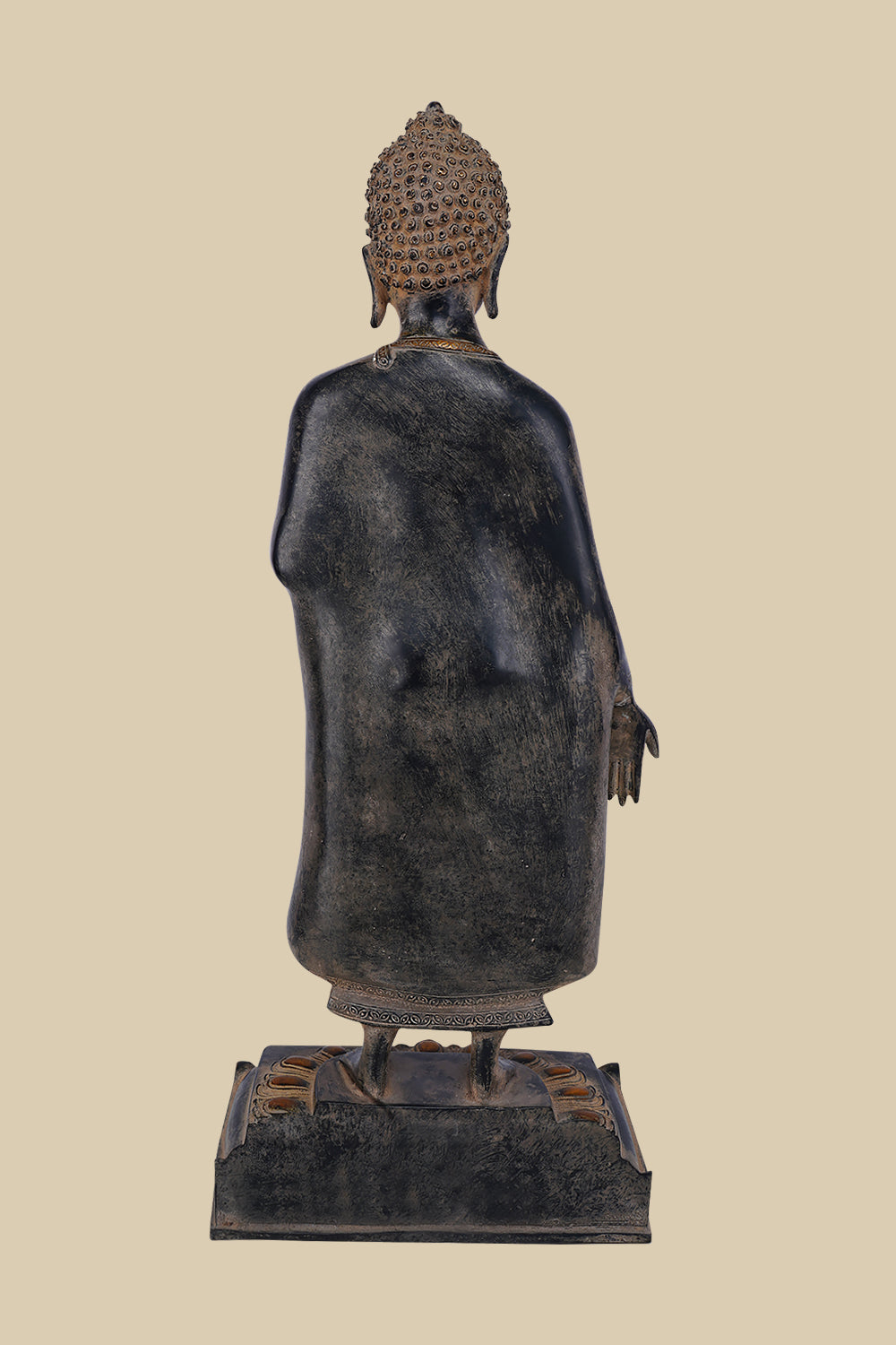 Back view of a standing brass sculpture of Lord Buddha, showing the details of his robe's drape, the intricate design of his hair, and the lotus pedestal