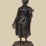 Brass statue of Lord Buddha standing with one hand raised in the Abhaya mudra (gesture of fearlessness and protection), wearing draped robes and standing on a carved lotus base.