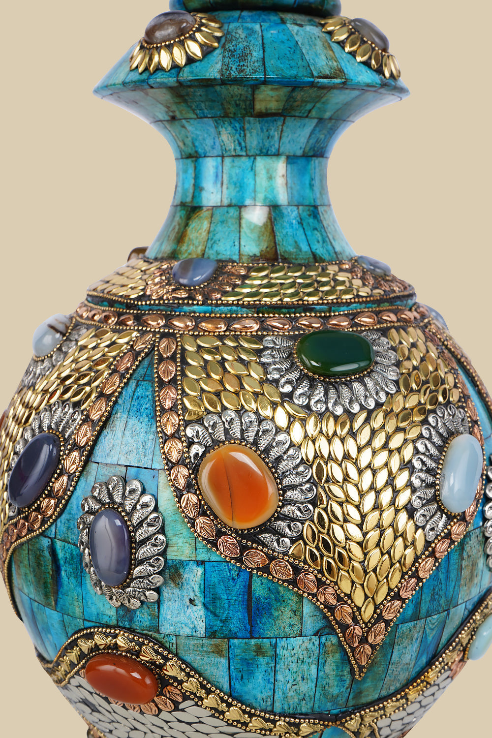 Detailed close-up of an azure Surahi vase made from camel bone, showcasing the intricate patterns of metalwork and colorful gemstone inlays on its surface.