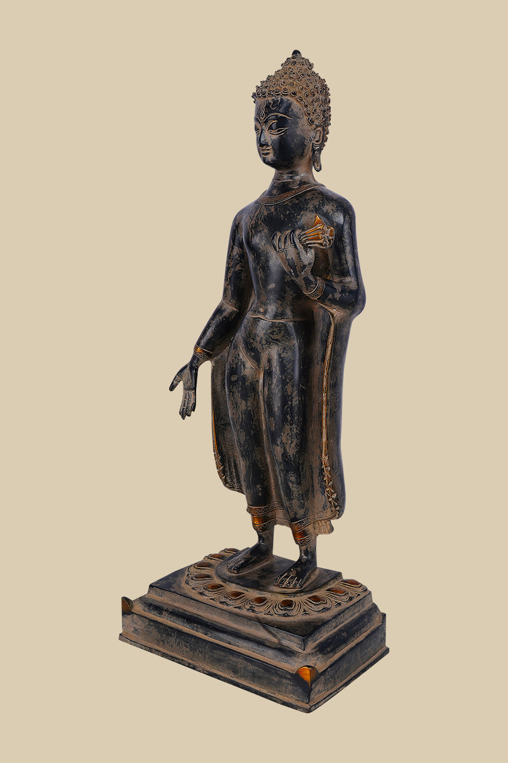 Brass standing Buddha figure in the Gandhara style, with flowing robes, one hand extended, and a serene expression, atop a detailed lotus base.