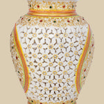 White marble vase featuring intricate openwork undercut carving, hand-painted with gold accents and embellished with embedded red and green gemstones, showcasing a delicate lattice design.