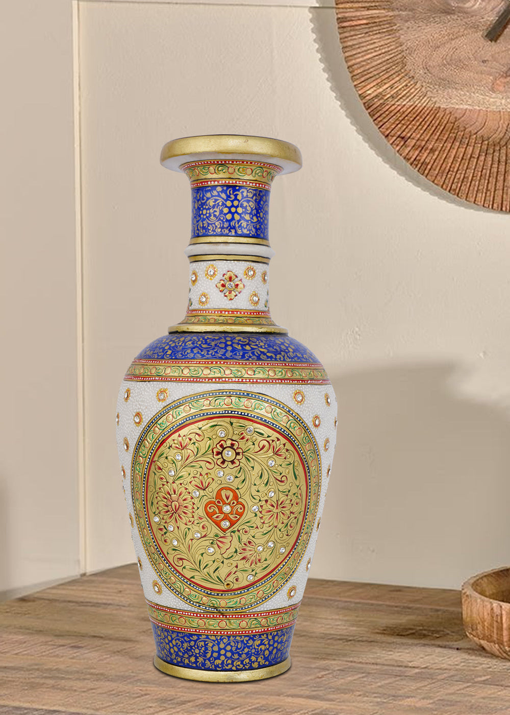 Ornate white marble flower vase meticulously hand-painted with traditional Indian motifs in vibrant blue, red, and green, highlighted with gold accents and small embedded gemstones.