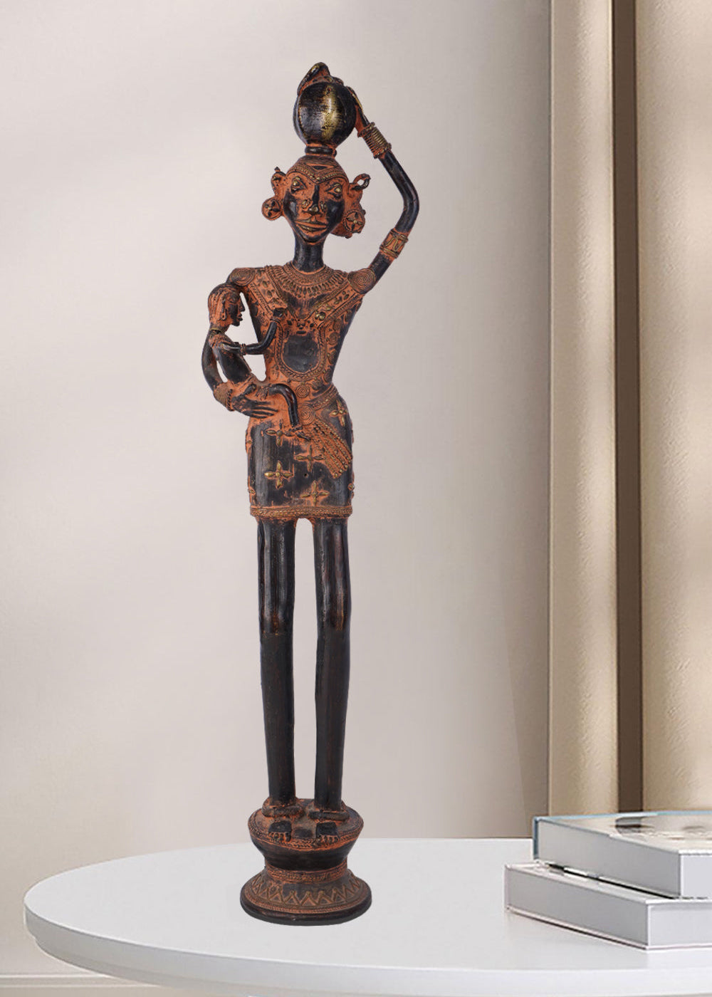 Dark brass figure depicting a rural woman carrying a small child in one arm and balancing a pot on her head. The antique-style sculpture features traditional adornments and stands on an ornate base.